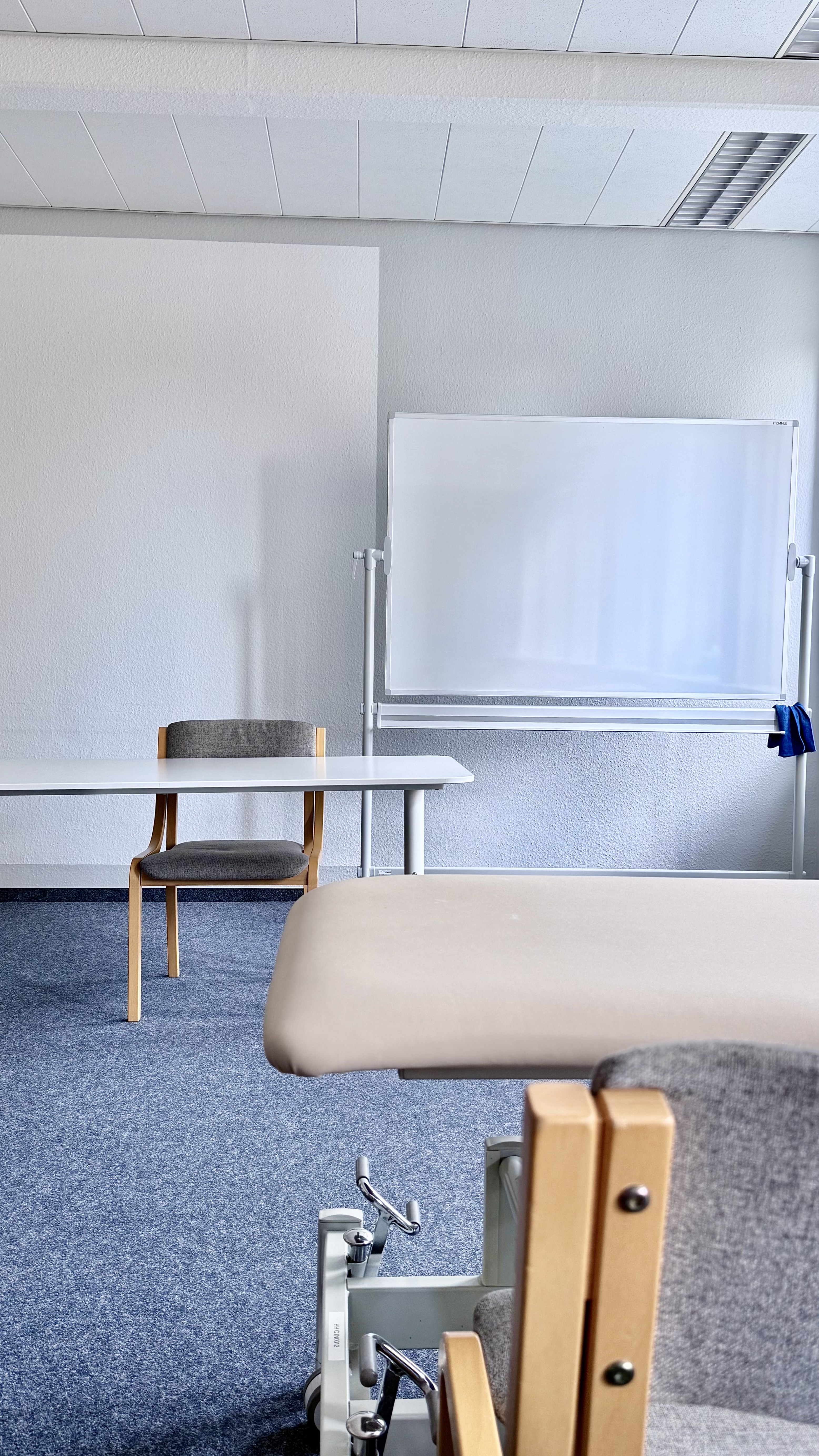 Behandlungsliege vorn und hinten Tisch mit Stühl und White Board